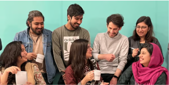 Team members sharing tea and laughing